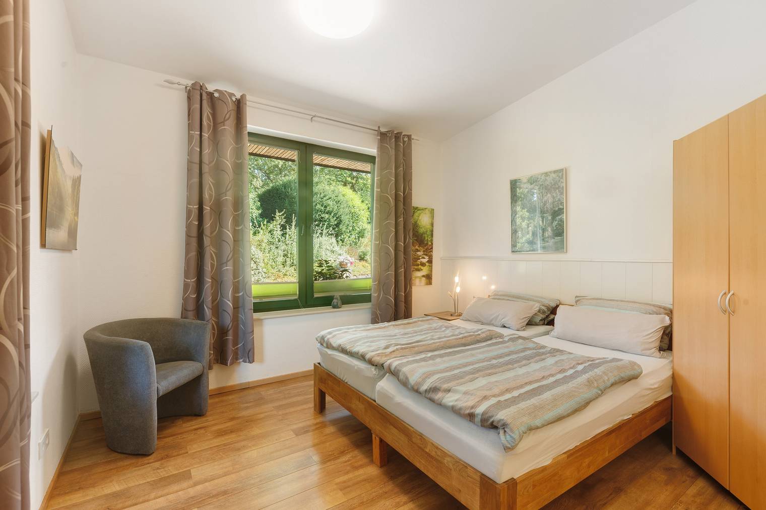 Schlafzimmer mit Doppelbett und Gartenblick